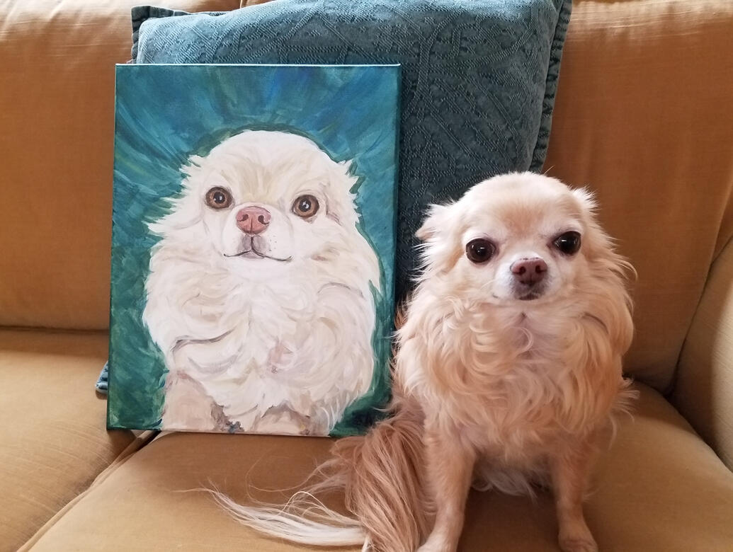 Dog sitting next to its portrait totally impressed